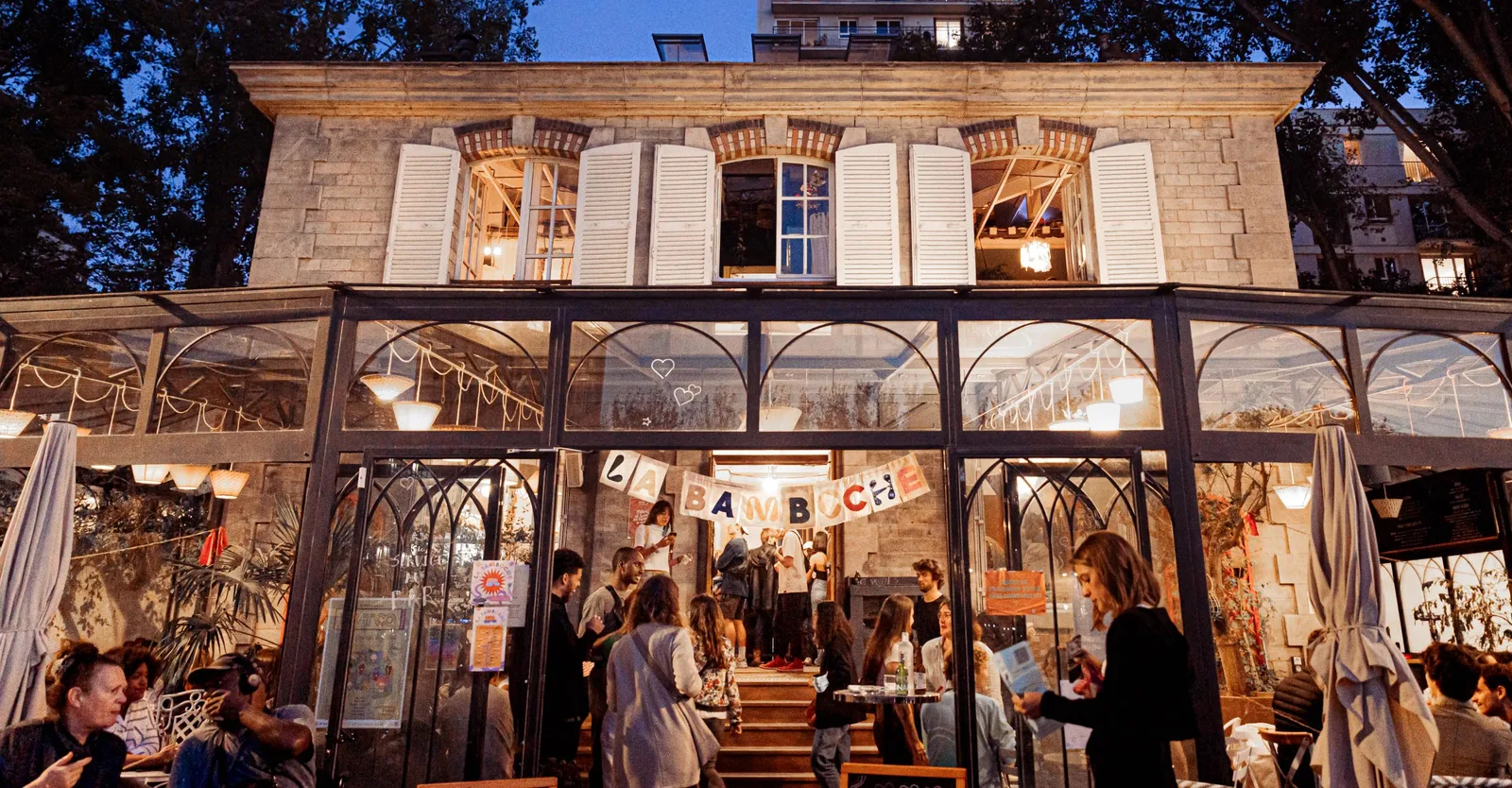 evening street-level café with warm lighting and bustling crowd of patrons., le pavillon des canaux, paris