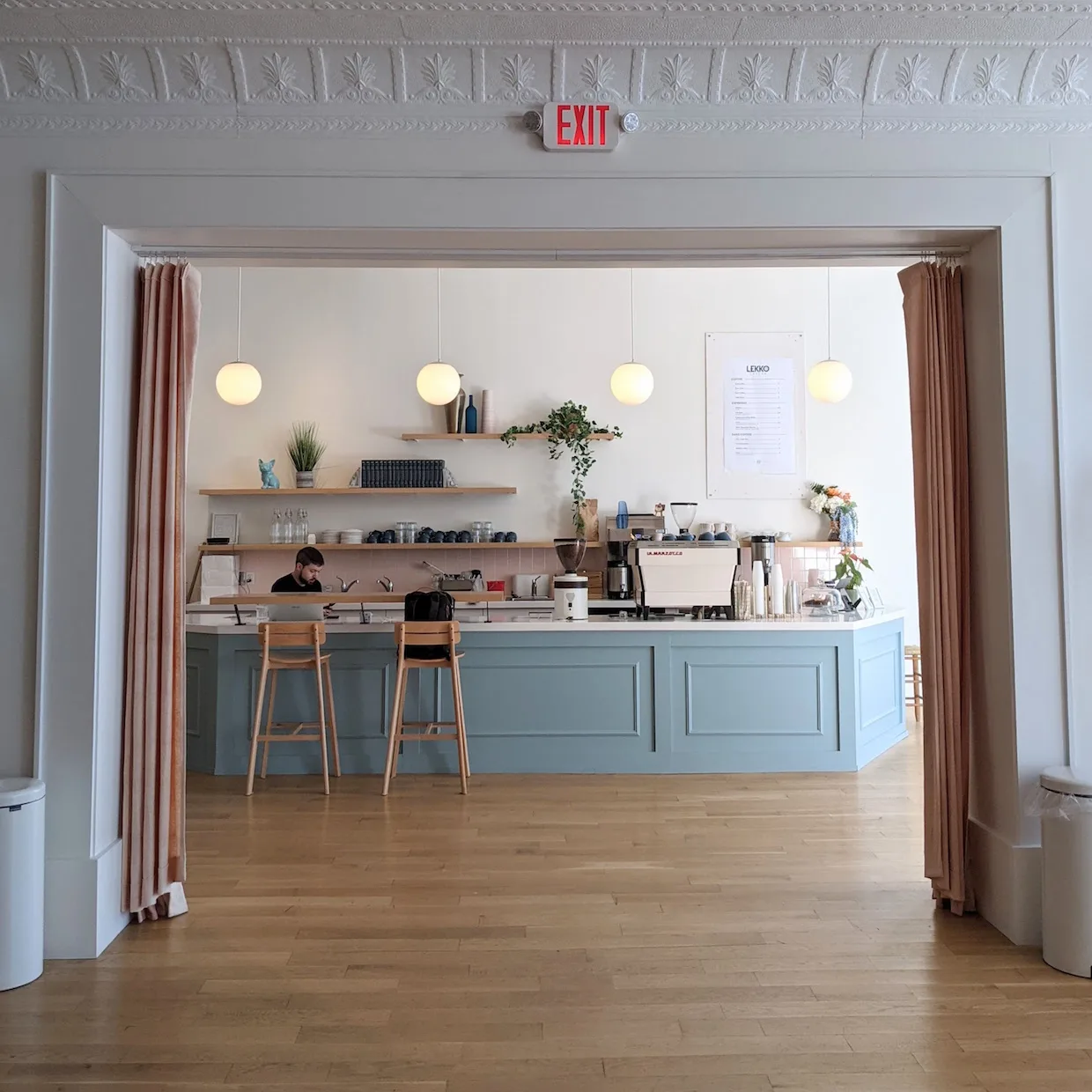 modern cafe interior with blue counter, wooden shelves, pendant lights, and barista., lekko coffee, cleveland