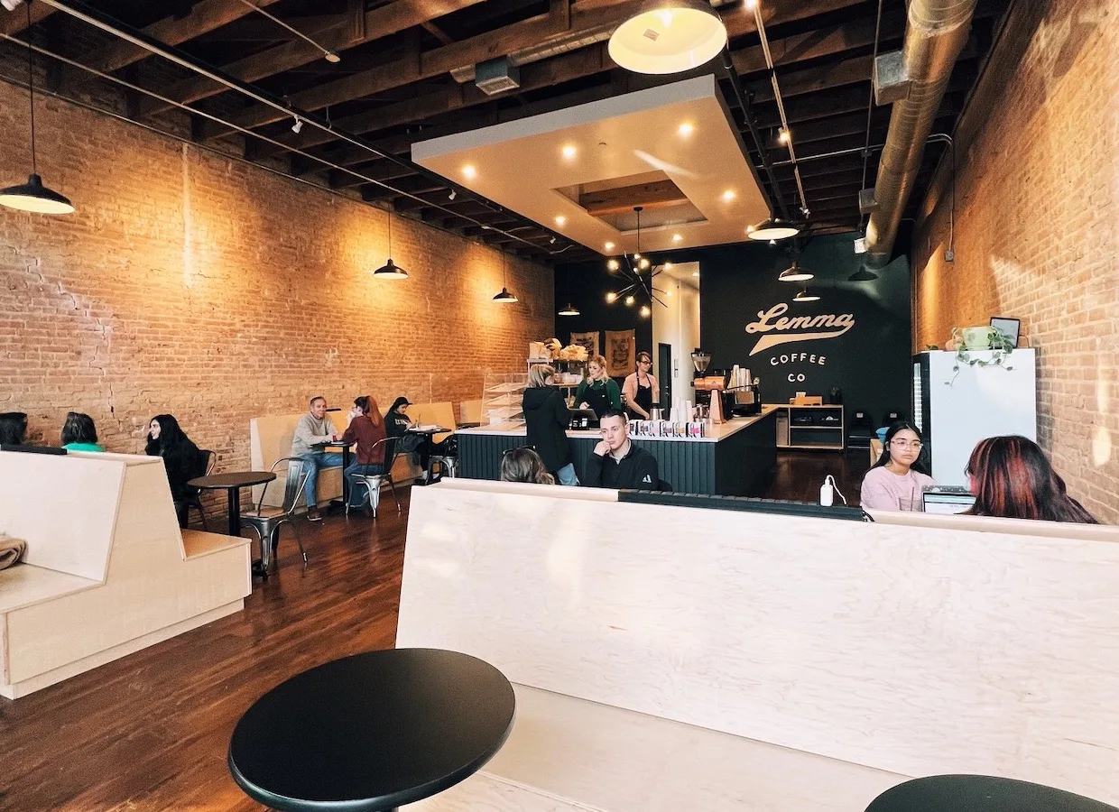 modern coffee shop interior with exposed brick, pendant lights, and counter seating., lemma coffee co, dallas