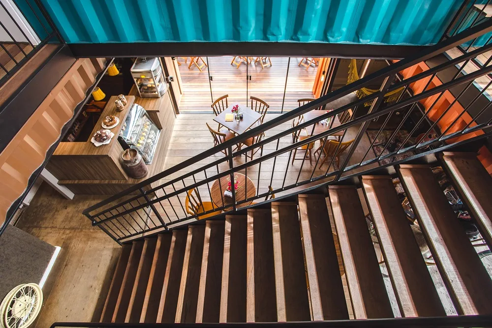 overhead view of loft space with wooden stairs, turquoise ceiling, dining area., leônidas bike café, curitiba