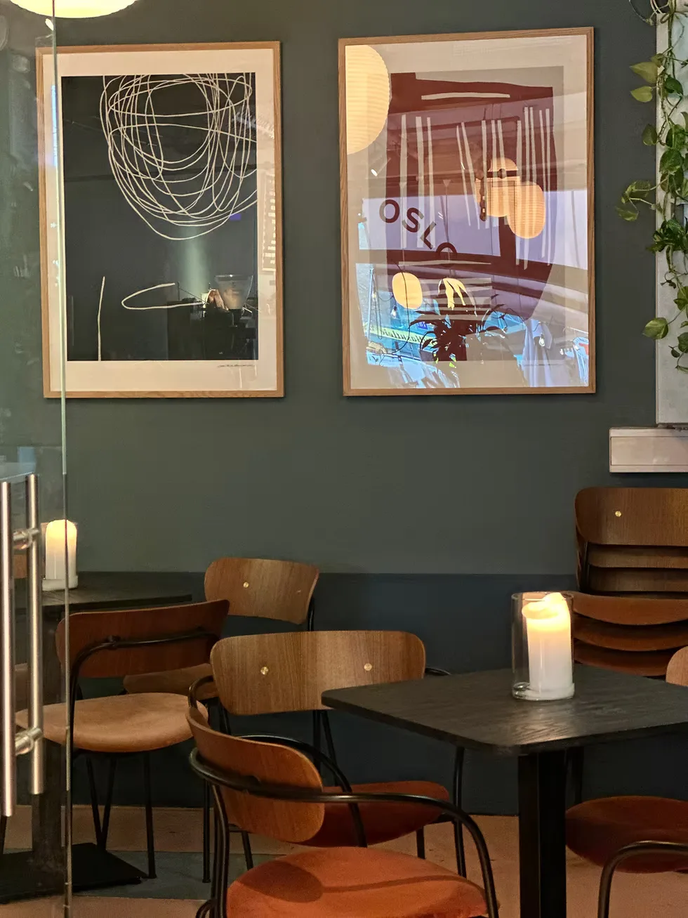 modern dining space with wood chairs, dark table, and abstract wall art., lille oslo kaffebrenneri, oslo