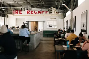 modern café interior with counter service, customers seated at tables, industrial ceiling., little bear coffee shop & wine ba