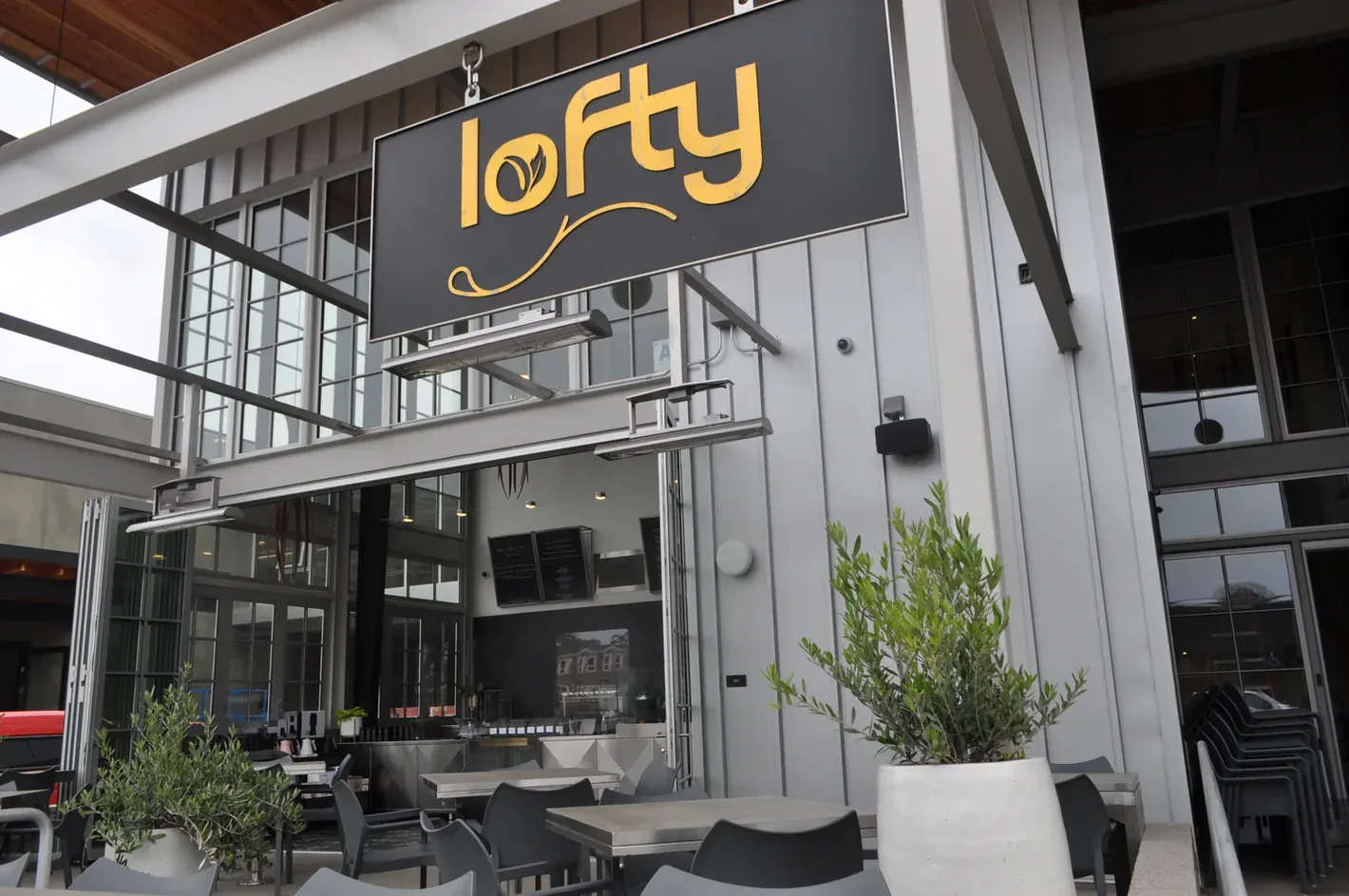 modern restaurant storefront with "lofty" signage, outdoor seating, and potted plants., lofty coffee co., san diego