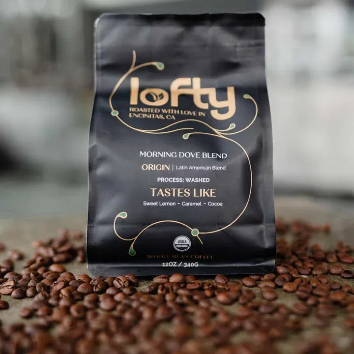 lofty coffee bag surrounded by scattered whole bean coffee on surface., lofty coffee co., san diego
