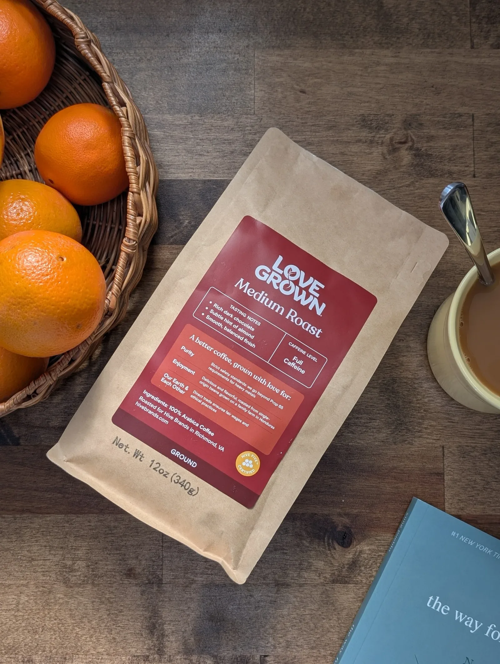 love grown medium roast coffee bag with oranges, cup, and book on wood surface., love grown, denver