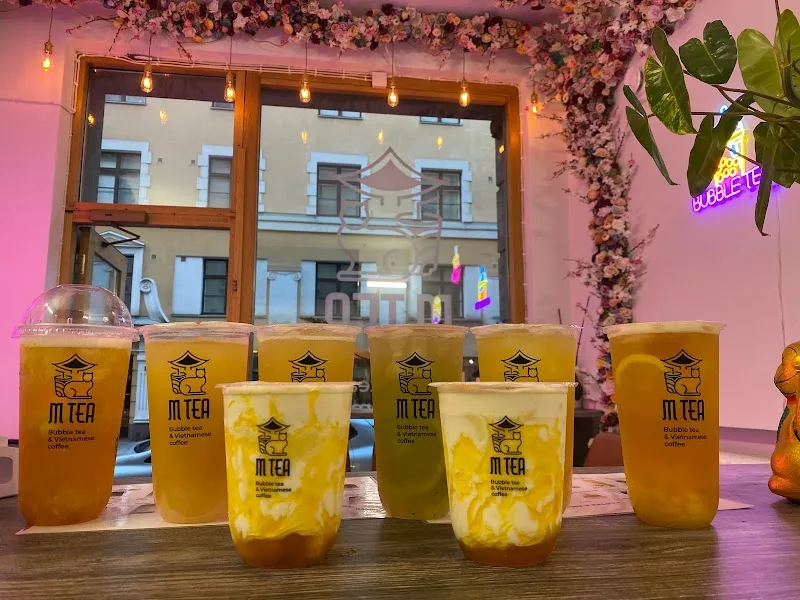 tea shop display with various bubble tea drinks and pink floral decorations., m tea, helsinki