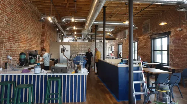 industrial brick loft space with counter seating, exposed ductwork, and wooden floors., mango tree coffee, englewood