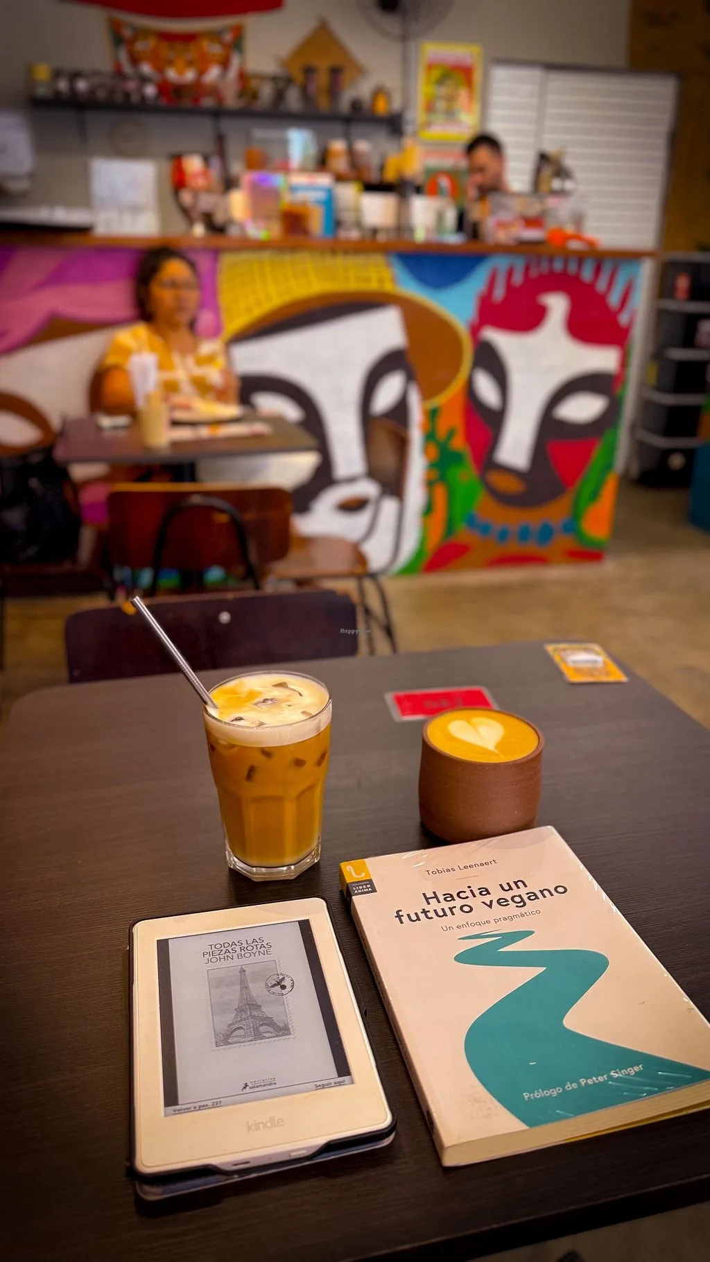 iced coffee and latte with books in colorful cafe interior space., manifesto café, curitiba