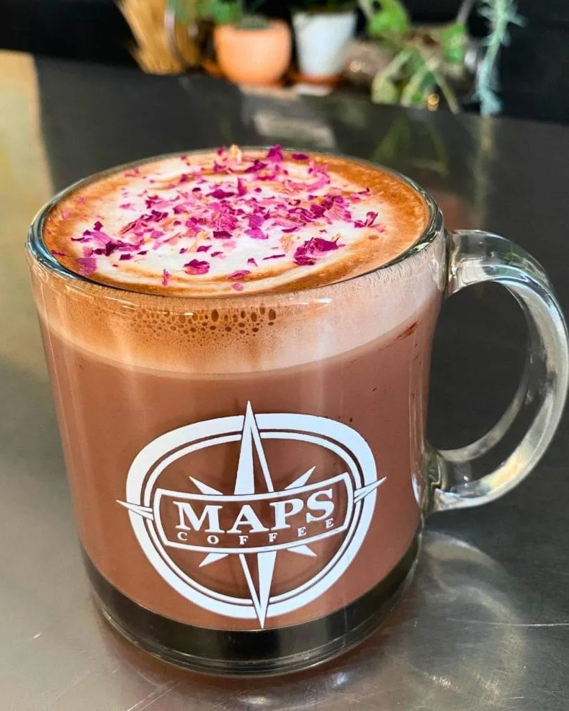 maps coffee branded mug with rose petal-topped latte and creamy foam., maps coffee roasters, kansas
