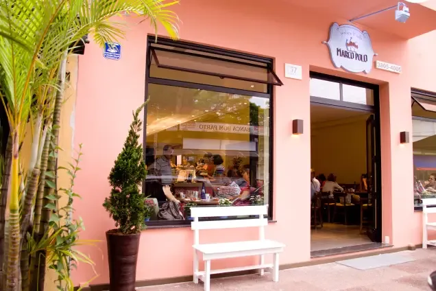 pink storefront with large window, potted plants, and white bench seating., marco polo gelateria & caffè, são paulo