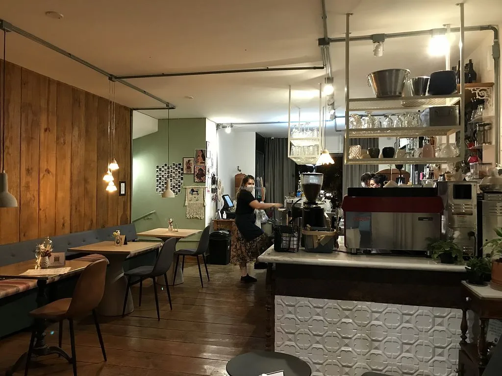 modern café interior with barista operating espresso machine behind counter., marilda café, brasília