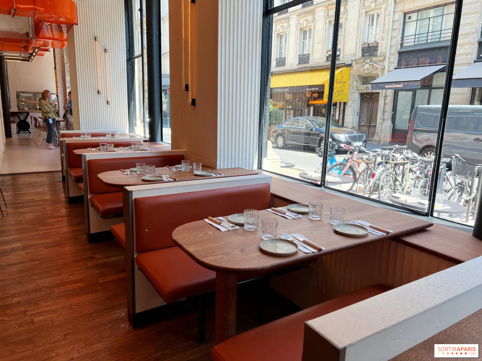 modern restaurant interior with booth seating overlooking parisian street scene., maslow 1er, paris