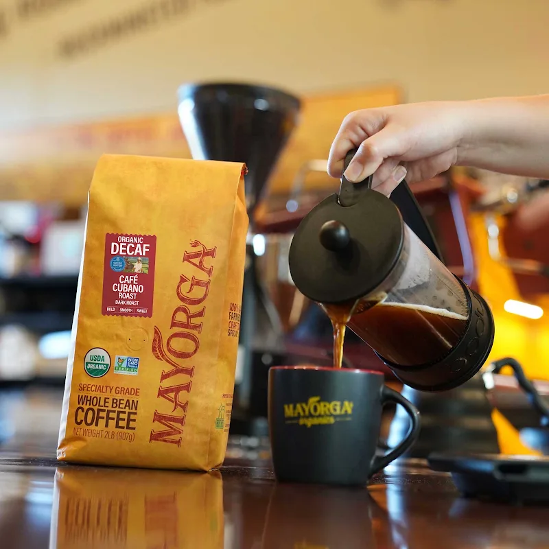 hand pouring decaf cuban coffee from french press into mayorga branded mug., mayorga coffee, rockville