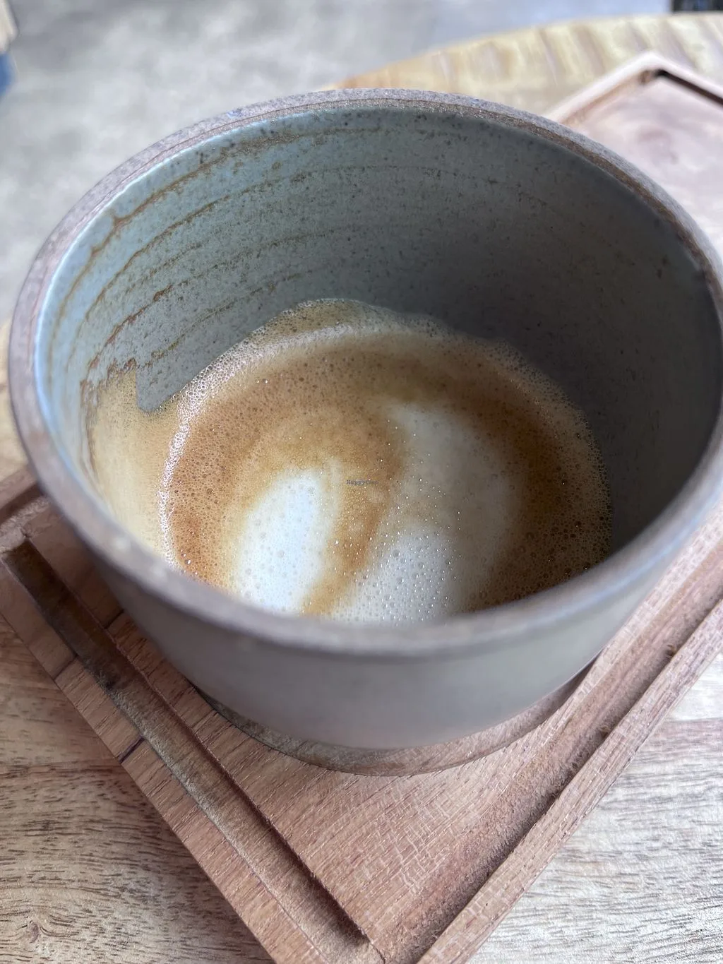 creamy cappuccino with thick foam in a ceramic cup on wooden coaster., meramanis coffee roaster, cologne