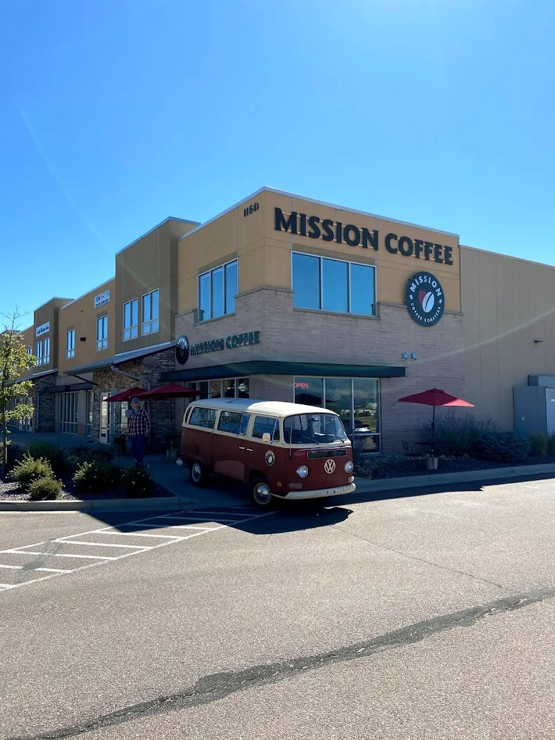mission coffee storefront with vintage vw van parked outside, red umbrellas visible., mission coffee roasters, inc., colorado