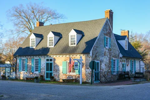 historic stone cottage with blue shutters and american flag displayed., mobjack bay coffee roasters, yorktown