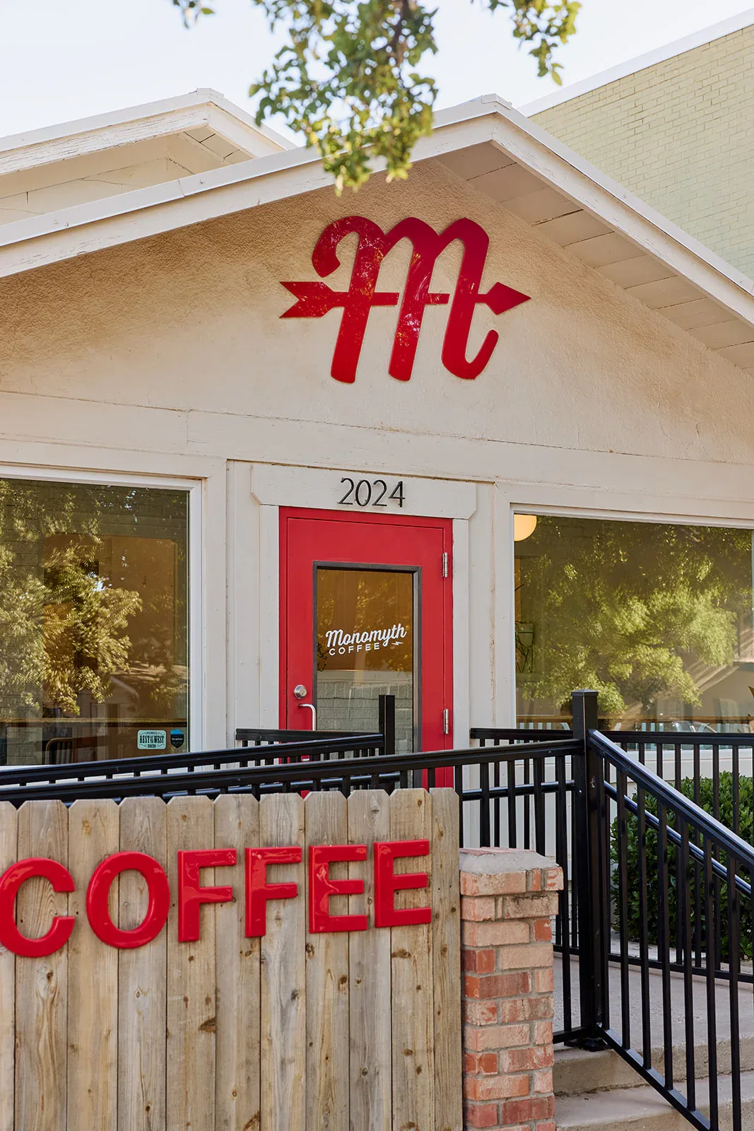 red arrow symbol and "coffee" sign on modern cream-colored storefront building., monomyth coffee, lubbock