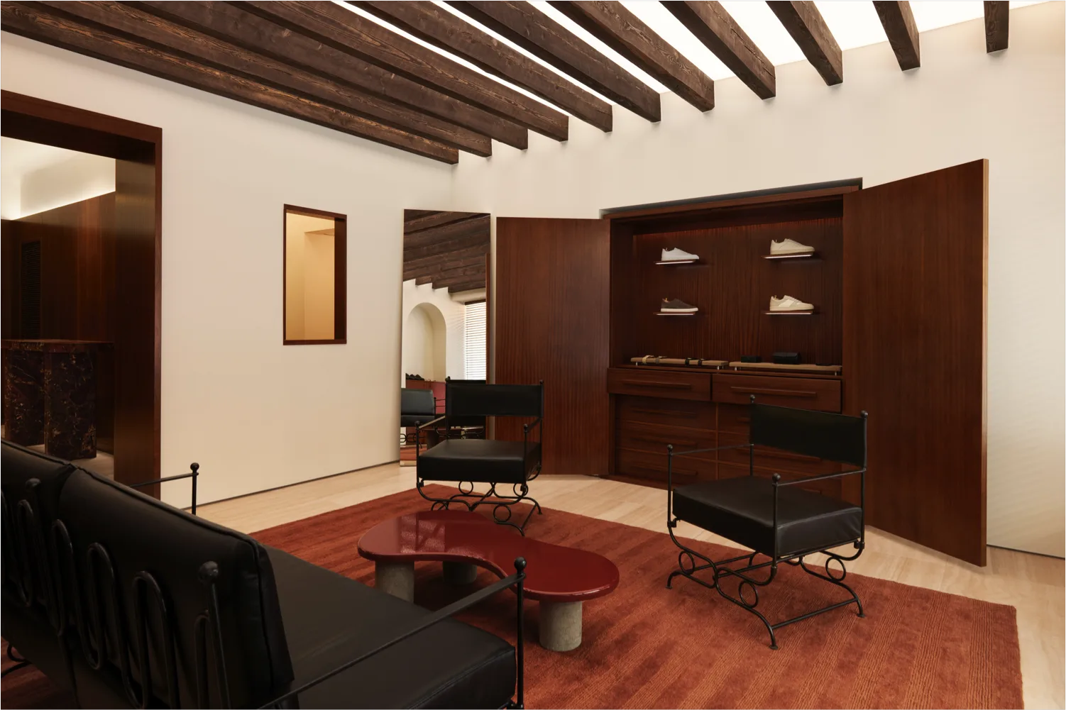 modern bedroom with exposed wooden beams, dark furnishings, and red accents., morjas flagship store, stockholm