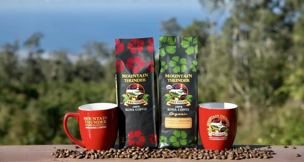 mountain thunder kona coffee products displayed with mugs and beans outdoors., mountain thunder coffee plantation, hawaii
