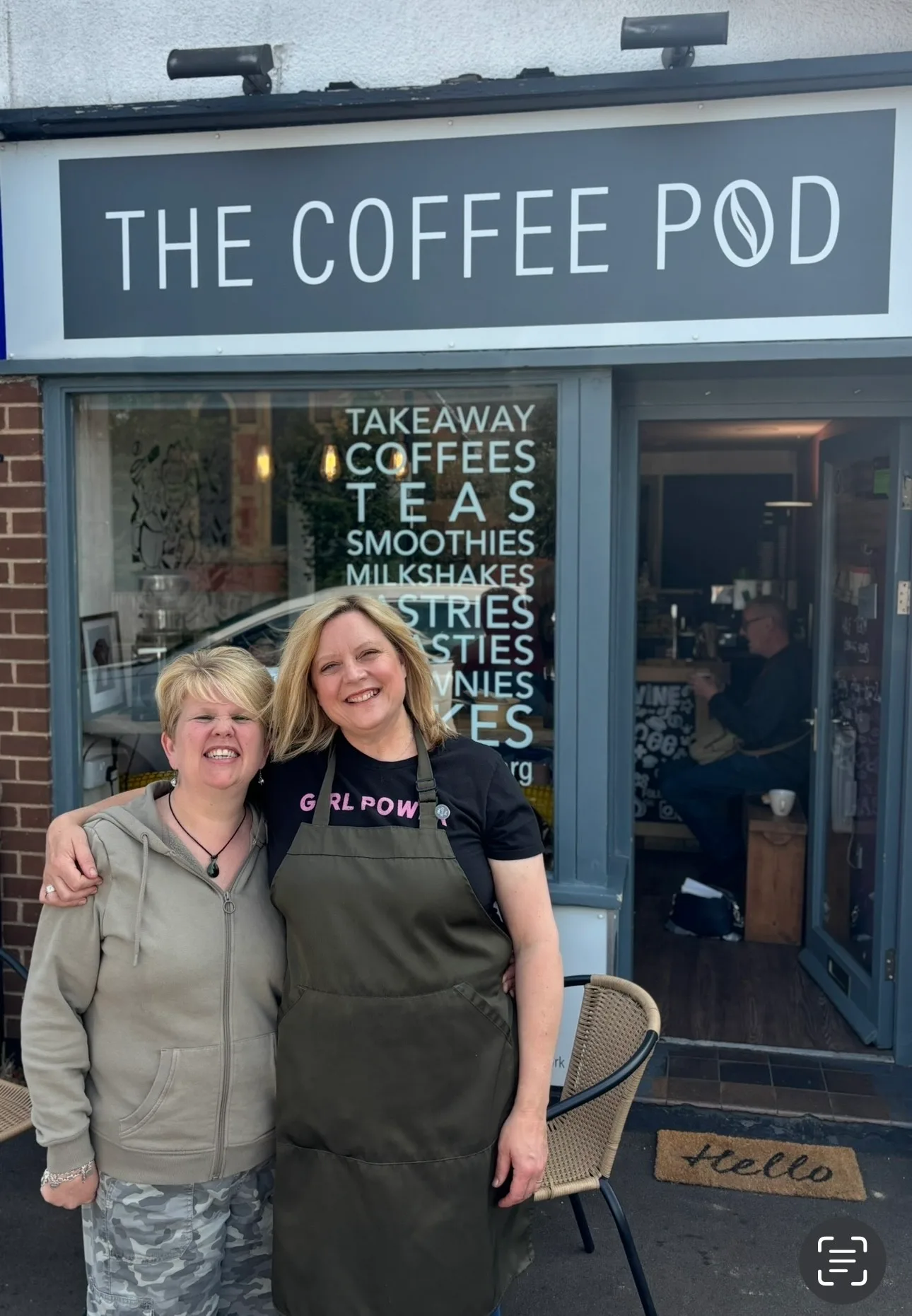 two smiling people standing outside the coffee pod café storefront., mr. pod - the happiest coffee that goes to your office, 
