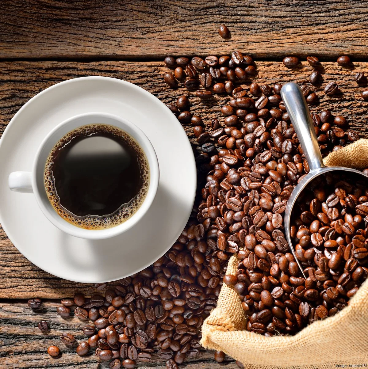 cup of black coffee surrounded by roasted beans and burlap sack on wood., muddy goose coffee co., dayton