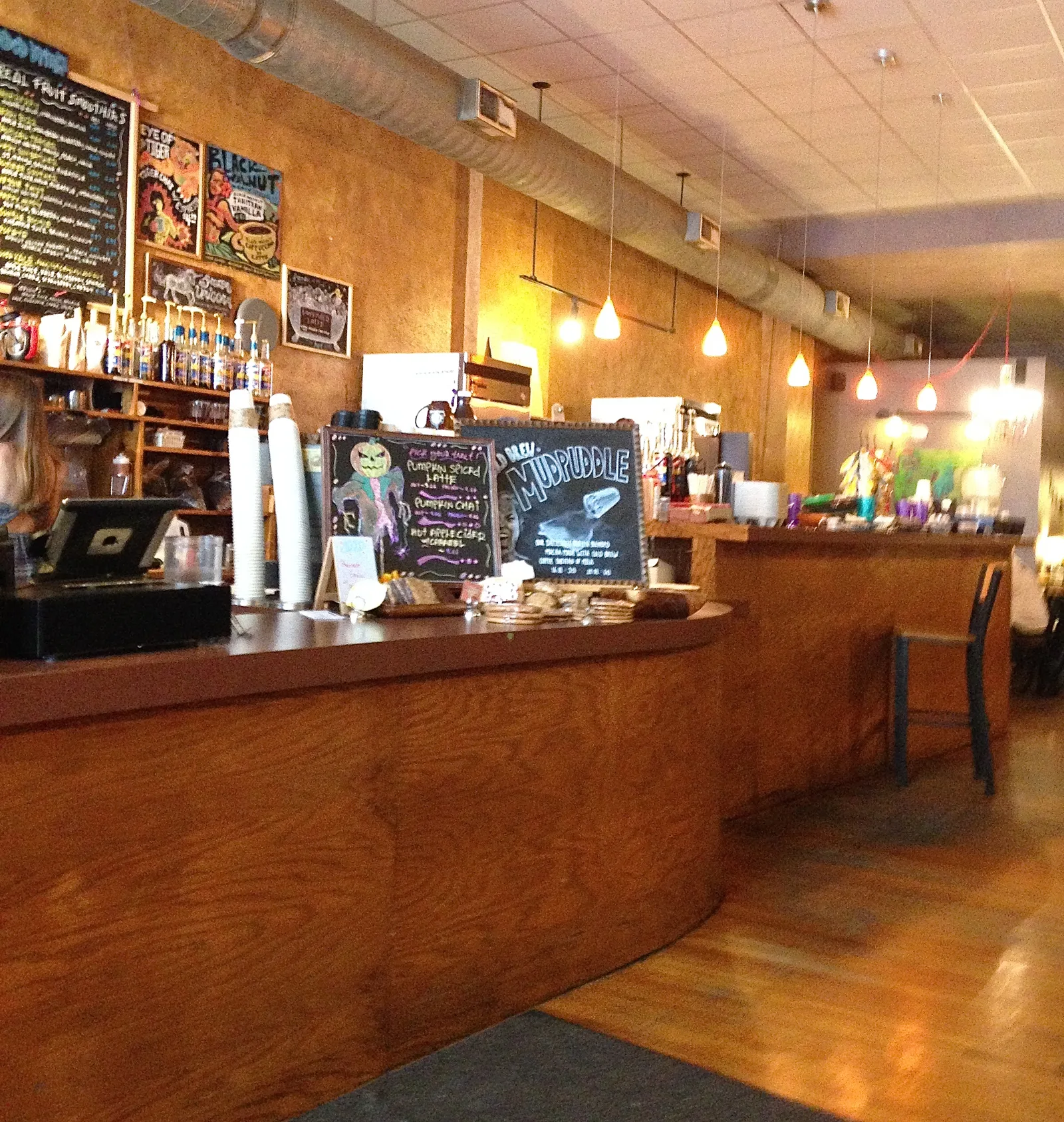 warm-lit coffee shop counter with chalkboard menu and pendant lights overhead., mudhouse coffee springfield, springfield