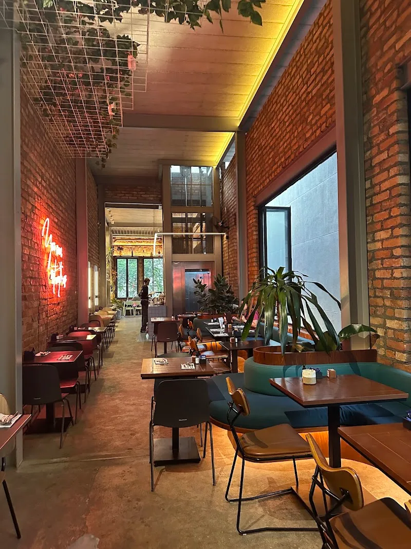 modern restaurant interior with exposed brick, warm lighting, and dining tables., mug.sp - casarão barão de tatuí, são paulo