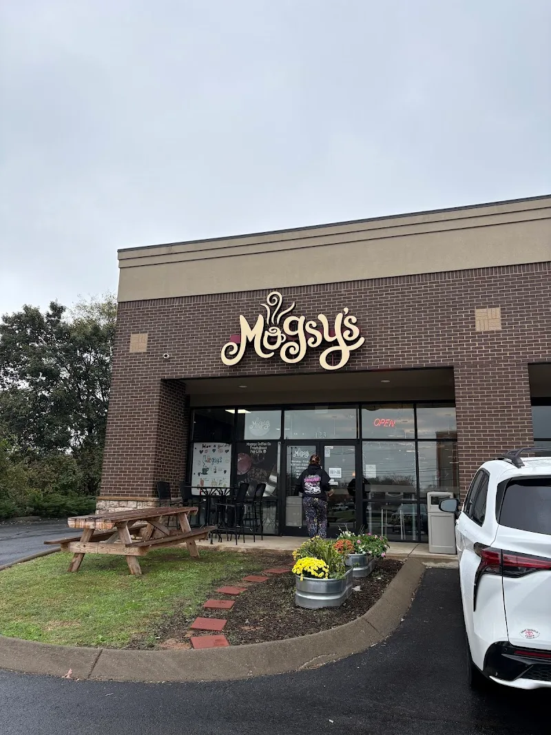 magus storefront with brick facade, picnic table, and white vehicle parked outside., mugsy's coffee co, clarksville