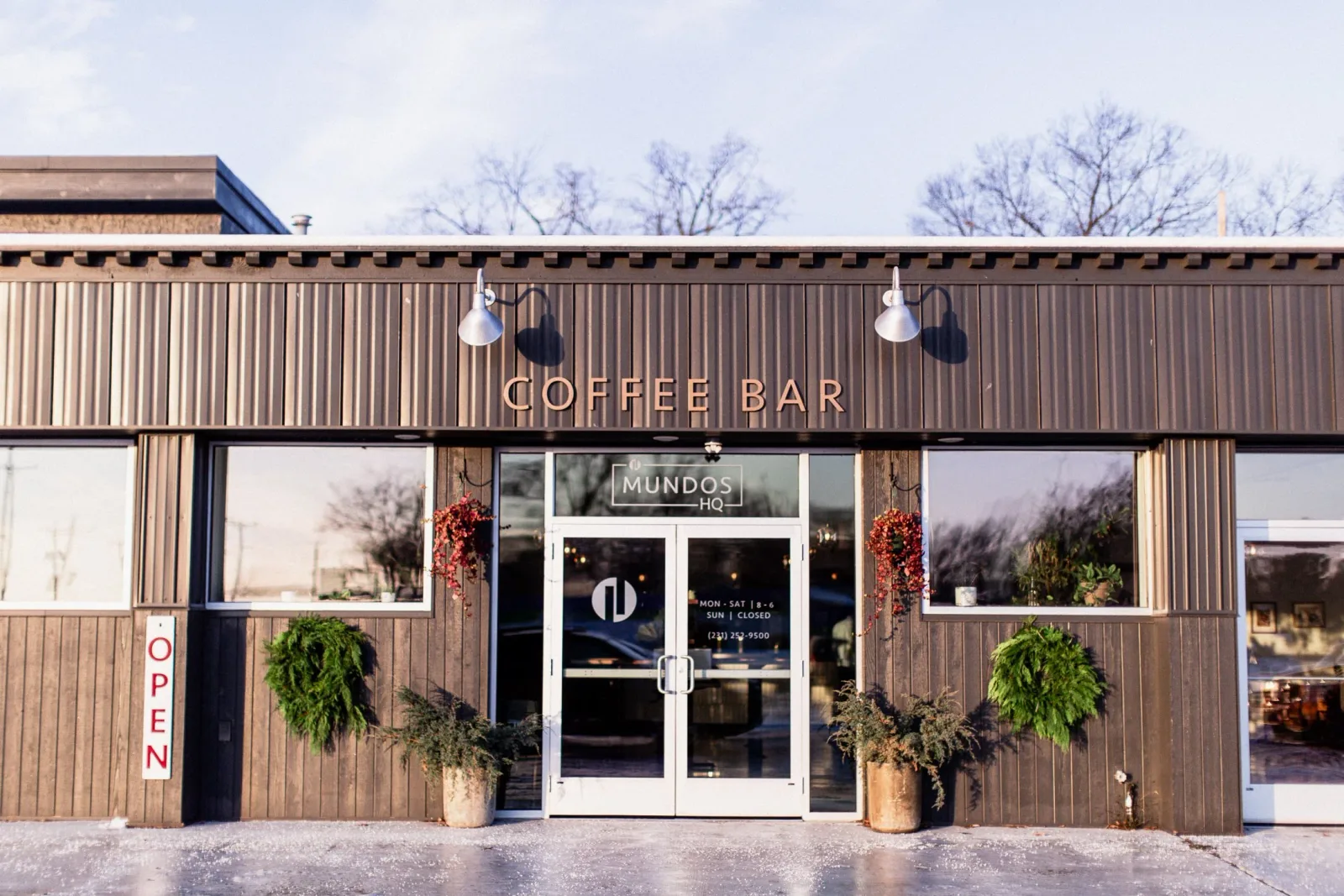 modern coffee bar storefront with corrugated metal facade and seasonal decorations., mundos roasting & co., traverse city