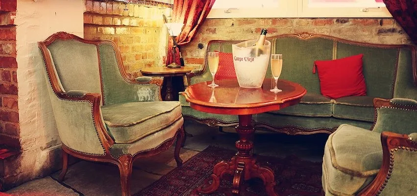 elegant lounge with upholstered chairs, red tables, and champagne glasses displayed., musikens hus, gothenburg