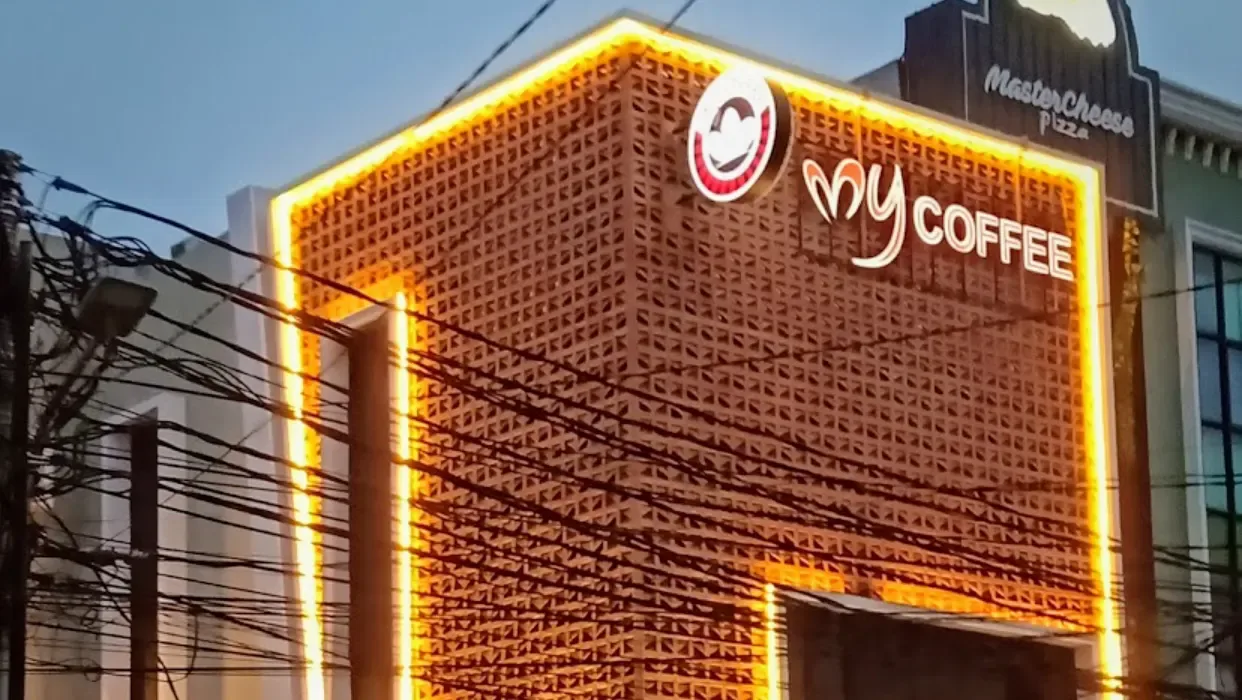 illuminated neon-framed coffee shop storefront with brick facade and signage., muyen coffee and roastery tebet, jakarta