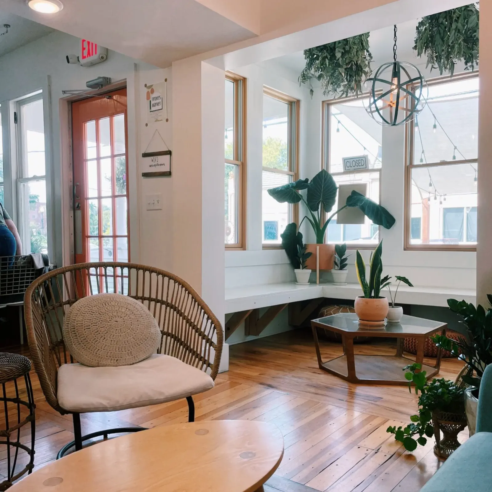 bright modern cafe interior with plants, rattan chair, and large windows., myrtle and cypress, omaha
