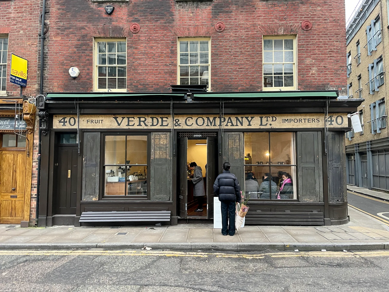 historic storefront with black facade, cream signage, and customers browsing inside., nagare coffee, london