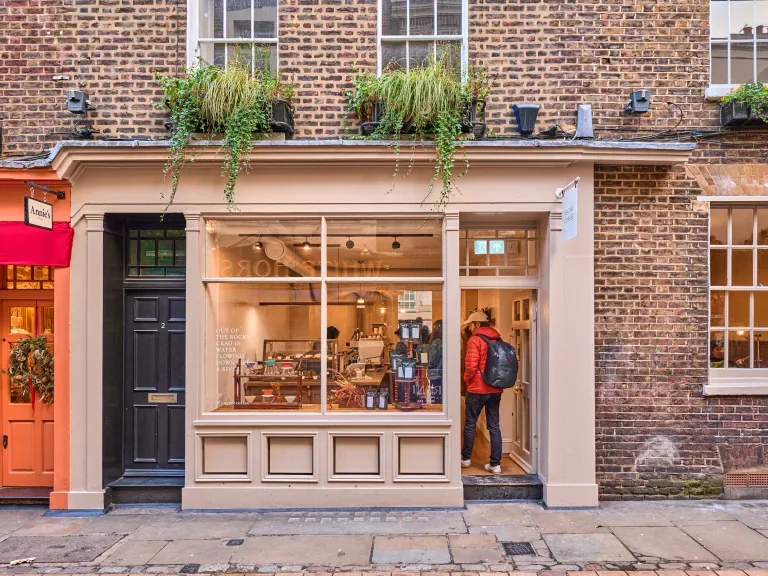charming brick storefront with large windows, hanging plants, and street-level display., nagare coffee, london