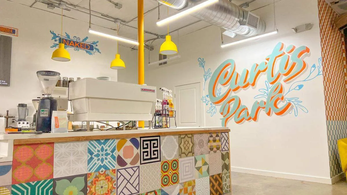 colorful juice bar interior with patterned counter, yellow pendant lights, and branding signage., naked coffee, sacramento