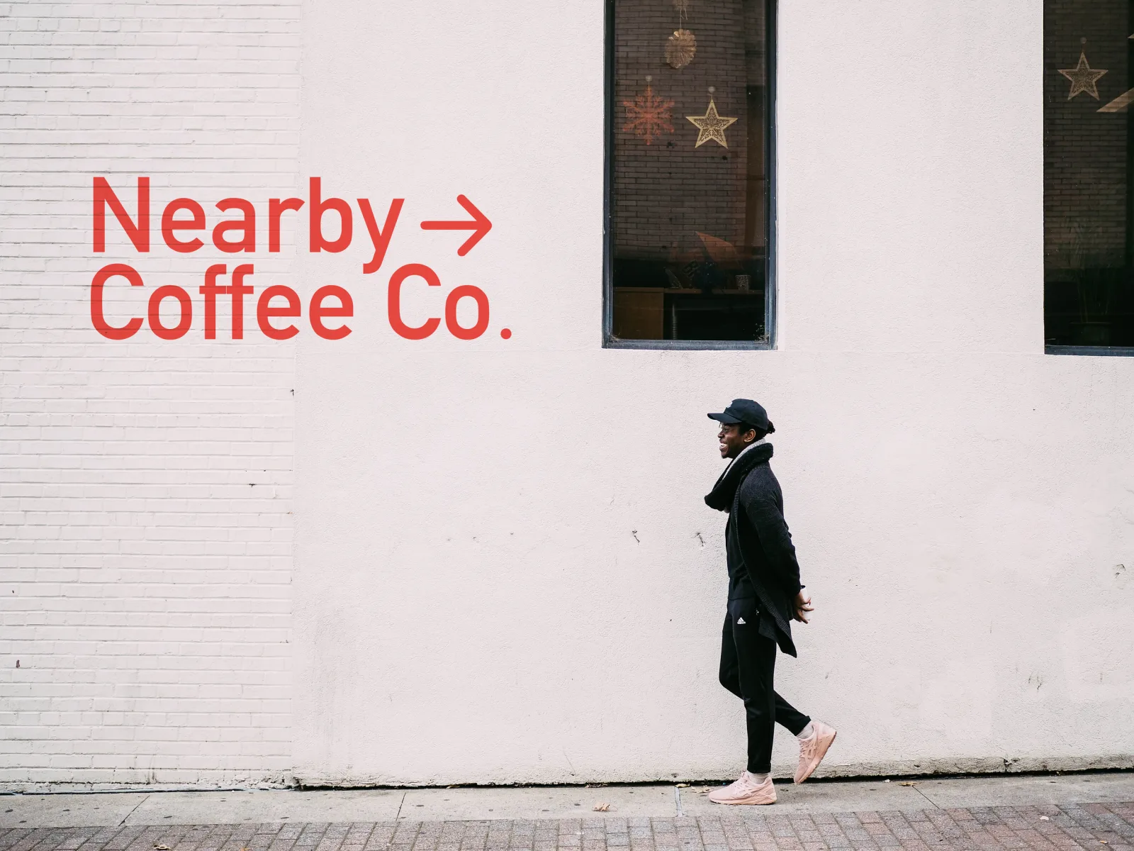 person jogging past white brick wall with red "nearby coffee co." sign., nearby coffee co. catering services, austin