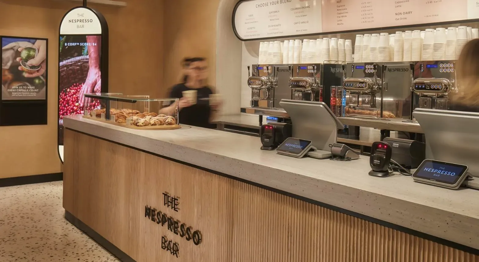 modern nespresso bar counter with espresso machines, menu boards, and pastries displayed., nespresso boutique, são paulo