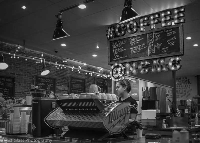 barista operating espresso machine in vintage-style coffee shop interior., new city microcreamery, hudson