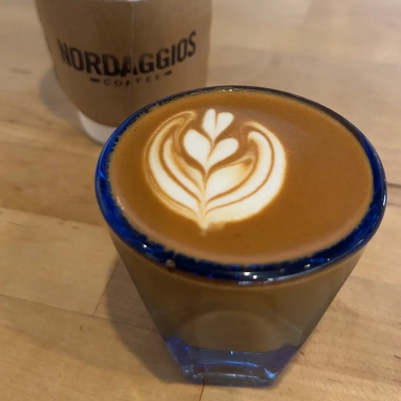 latte with heart latte art in blue-rimmed cup at coffee shop., nordaggio's coffee, tulsa