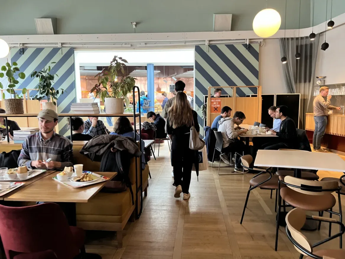 modern café interior with diners seated at tables eating meals and socializing., nymble, stockholm