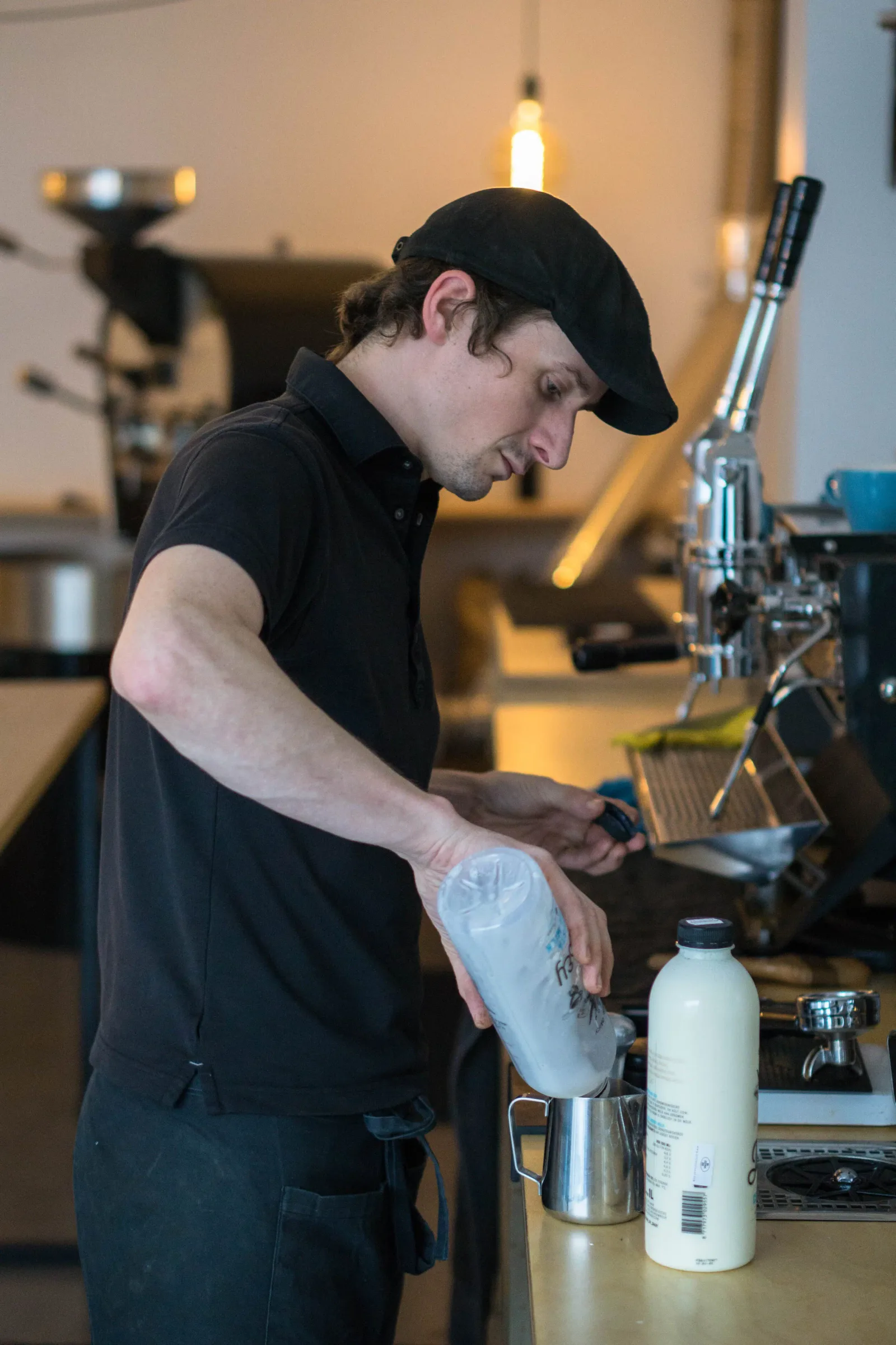 barista steaming milk pitcher at espresso machine in café setting., ohøj coffee roasting, utrecht