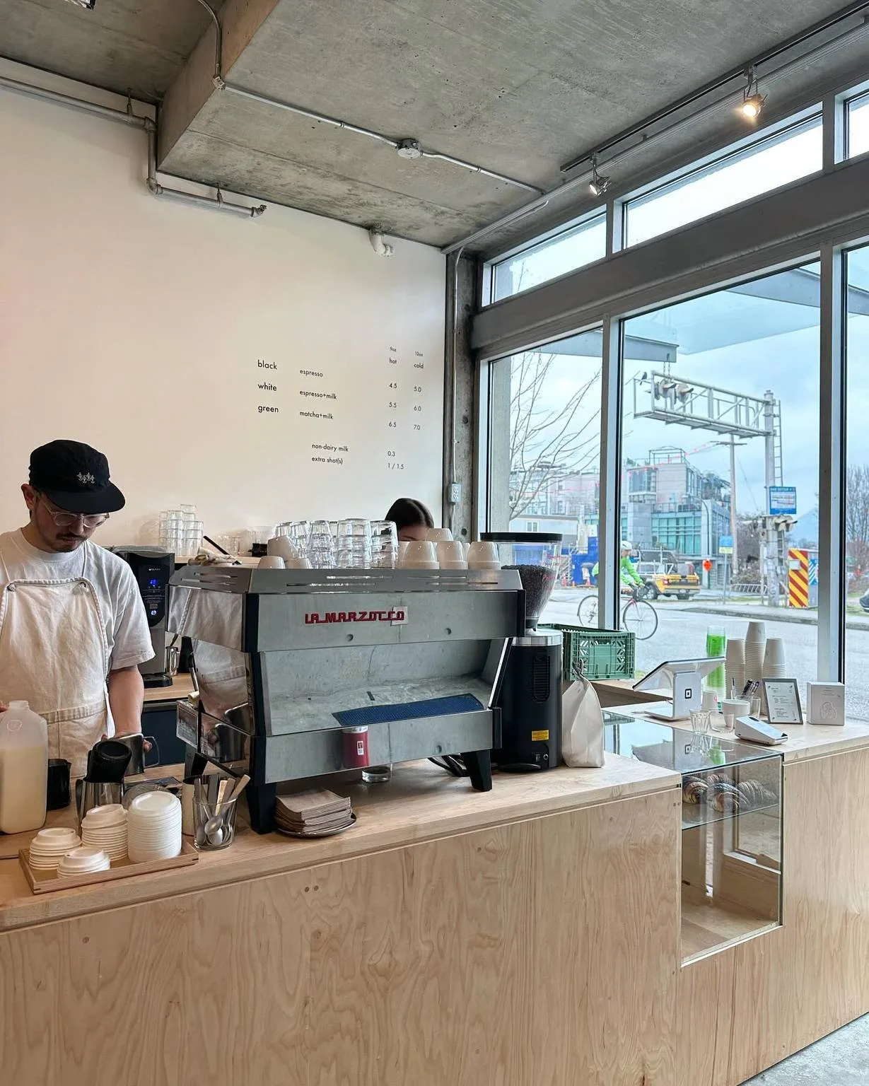 modern minimalist coffee shop with la marzocco espresso machine and city views., oidē, curitiba