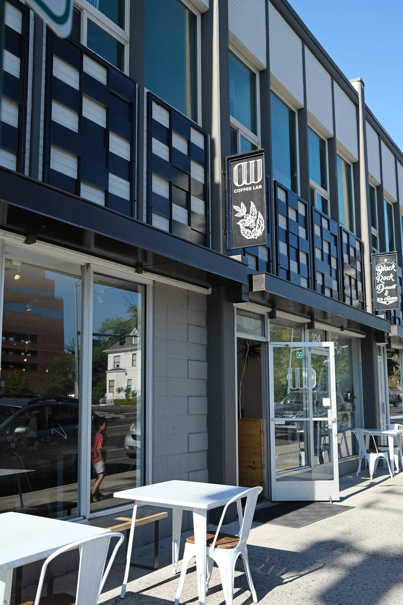 modern coffee shop storefront with white outdoor seating and dark facade., old world coffee lab, reno