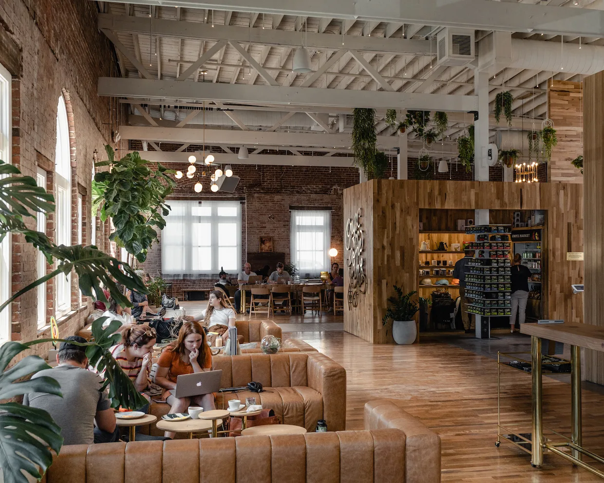 modern loft workspace with exposed brick, plants, leather seating, and wooden retail counter., onyx coffee lab, rogers