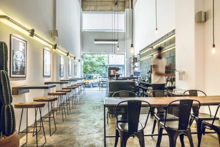 modern café interior with high ceilings, pendant lights, and wooden tables., oop café, belo horizonte