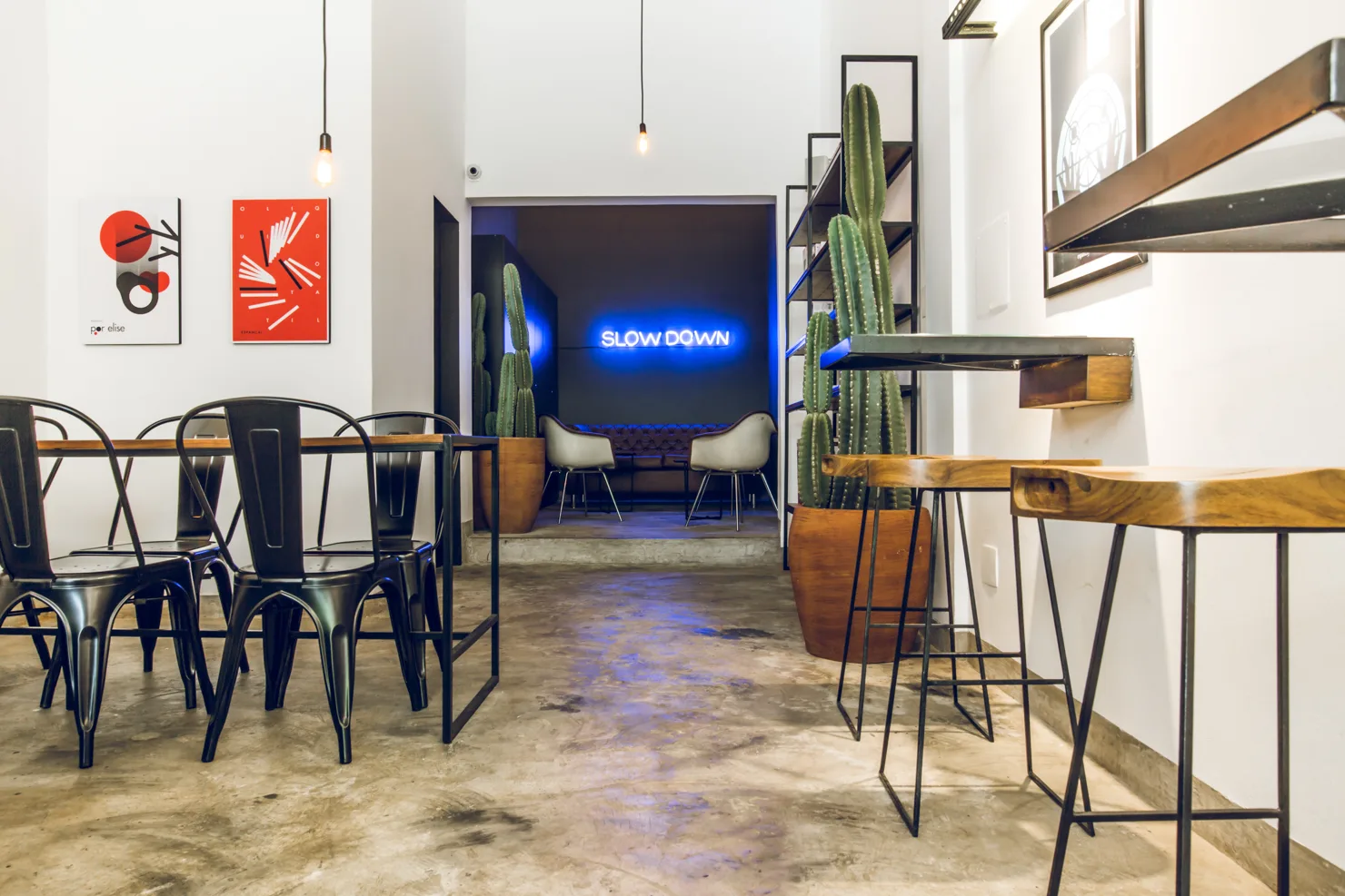 modern cafe interior with neon "slow down" sign and potted cacti plants., oop café, belo horizonte
