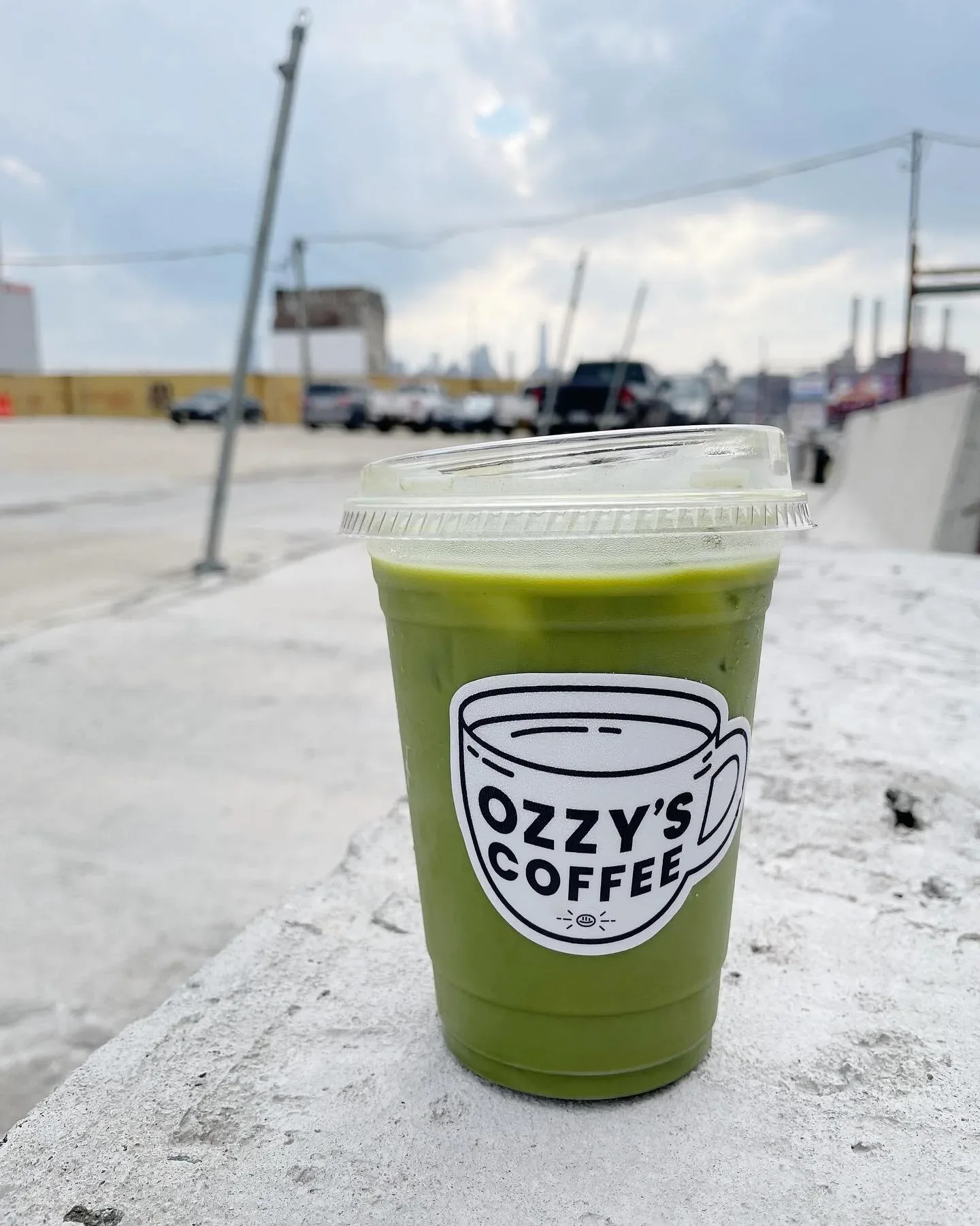 green matcha beverage from ozzy's coffee sits on concrete rooftop., ozzy’s coffee, new york city