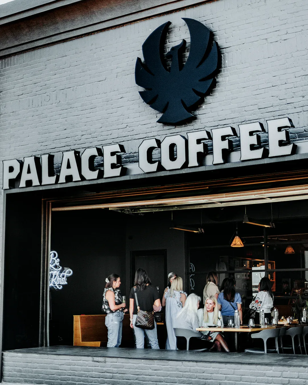 palace coffee storefront with customers inside and distinctive black bird logo above., palace coffee company, amarillo