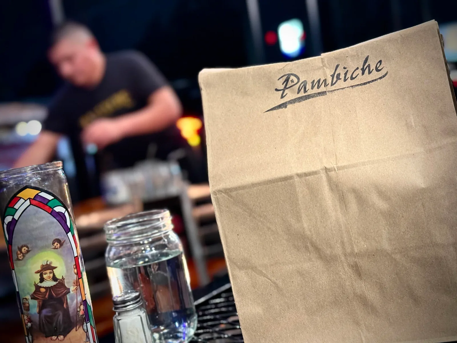 pambiche restaurant bag with religious candle and water glass on table., pambiche, portland