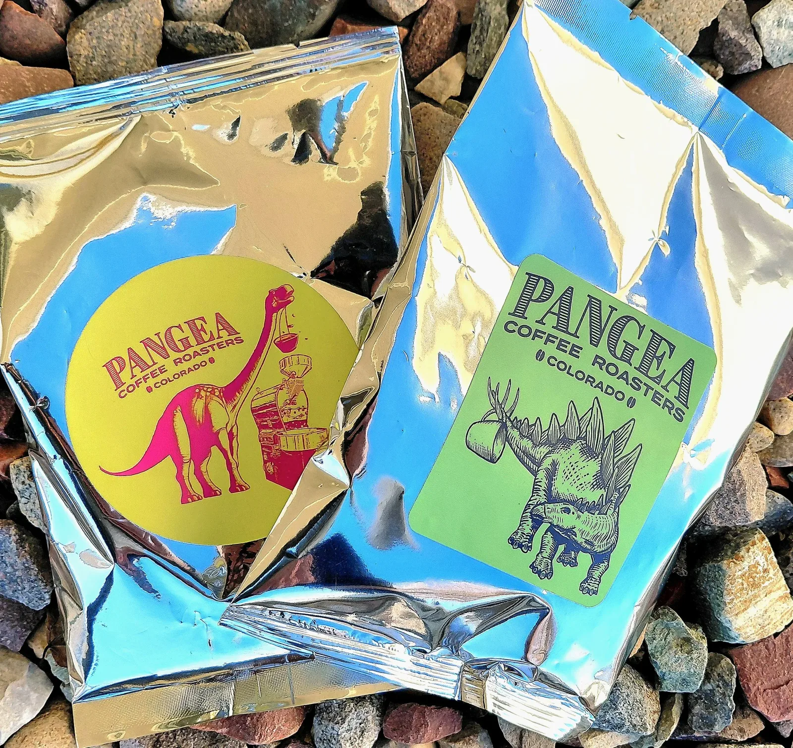 two colorful coffee bags from pangea coffee roasters in colorado on rocks., pangea coffee roasters, golden